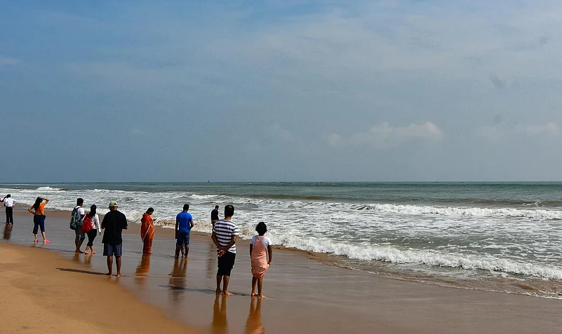People standing on a beach looking at ocean waves