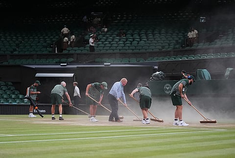 Workers arrange the court during the quarter-final men's singles match between Novak Djokovic of Serbia and Felix Auger-Aliassime of Canada, at the Wimbledon Tennis Championships in London, Tuesday, July 7, 2026. 