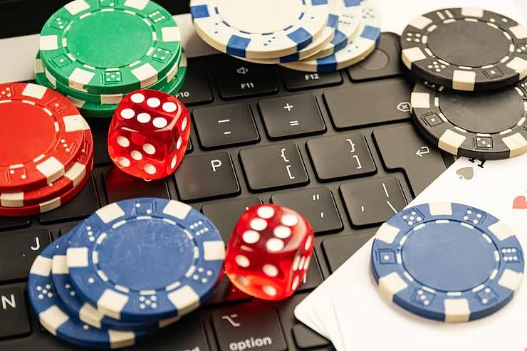 Online gambling chips and red dice on a keyboard