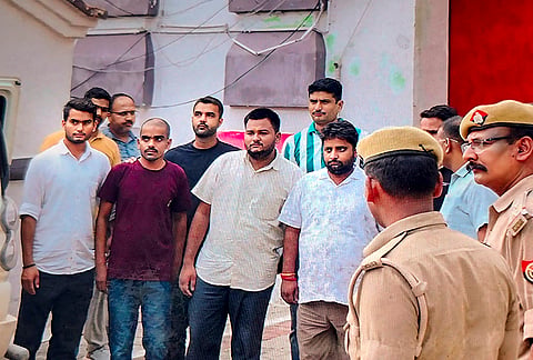 Police personnel escort three accused in the alleged Ram temple donation theft case after they were brought from jail on police custody remand, in Ayodhya. A local court granted one-day police remand to the accused for further investigation. 