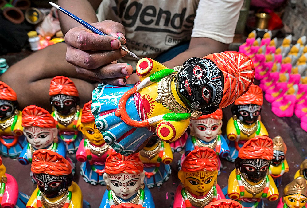 An artisan makes idols of Lord Jagannath, Balabhadra and Goddess Subhadra ahead of the Rath Yatra festival, in Nadia, West Bengal. - | Photo: PTI
