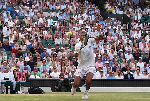 Felix Auger-Aliassime of Canada returns the ball to Novak Djokovic of Serbia in their quarter-final men's singles match at the Wimbledon Tennis Championships in London, Tuesday, July 7, 2026.