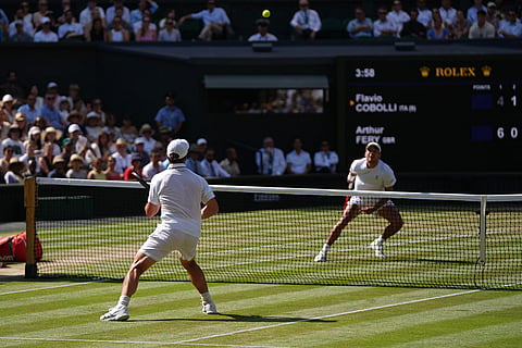 Flavio Cobolli of Italy and Arthur Fery of Britain, back to the camera, eye the ball during their quarter-final men's singles match at the Wimbledon Tennis Championships in London.