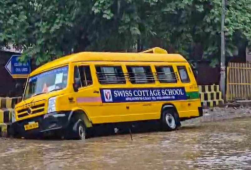 A school bus stuck in a waterlogged road after monsoon rains, in Gurugram, Tuesday, July 7, 2026.