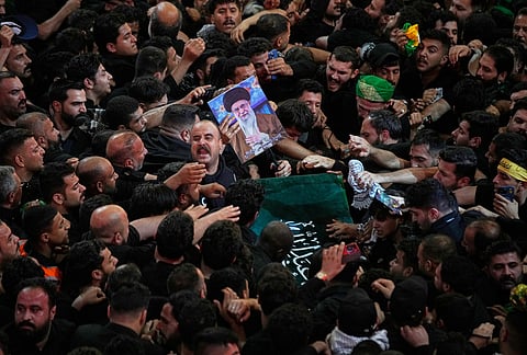 The coffin of the late Iranian Supreme Leader Ayatollah Ali Khamenei is carried through a tightly packed crowd as mourners jostle to reach and touch it outside the Imam Hussein Shrine in Karbala, Iraq, early Thursday, July 9, 2026. 