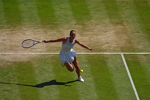 Marta Kostyuk of Ukraine returns the ball to Jasmine Paolini of Italy in their quarter-final women's singles match at the Wimbledon Tennis Championships in London.