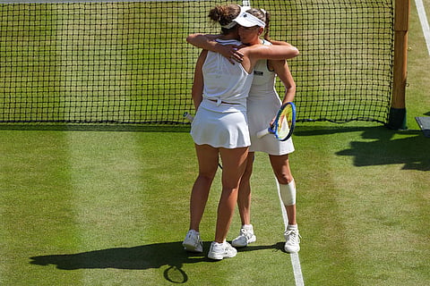 Linda Noskova of the Czech Republic hugs Elise Mertens of Belgium after the women's quarter-final singles match at the Wimbledon Tennis Championships in London.