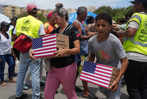 People affected by the earthquakes carry U.S. humanitarian aid after receiving it in La Guaira, Venezuela.