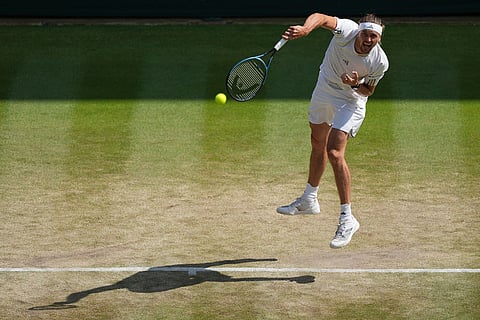 Alexander Zverev of Germany serves the ball during the men's singles quarter-final match against Taylor Fritz of the United States at the Wimbledon Tennis Championships in London.