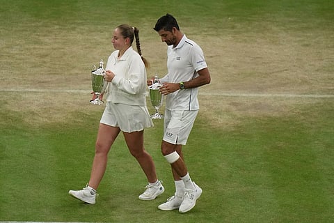 Jelena Ostapenko of Latvia and Marcelo Arevalo of El Salvador hold their trophies after defeating Marc Polmans of Australia and Storm Hunter of Australia in the mixed doubles final match at the Wimbledon Tennis Championships in London.