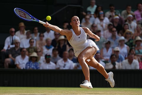 Marta Kostyuk of Ukraine returns the ball to Linda Noskova of the Czech Republic in their semifinal women's singles match at the Wimbledon Tennis Championships in London.