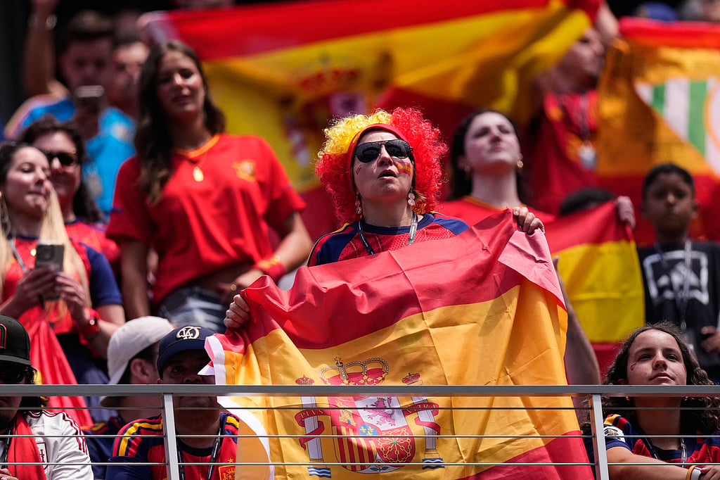 Fans hold up Spanish flags as they watch warmups before the World Cup quarterfinal soccer match between Spain and Belgium in Inglewood,