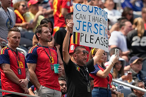 Belgium fans, one holding a placard, wait for the start of the World Cup quarterfinal soccer match between Spain and Belgium in Inglewood