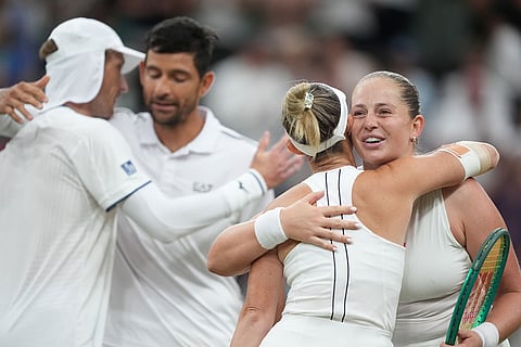 Jelena Ostapenko of Latvia and Marcelo Arevalo of El Salvador, hug Marc Polmans of Australia and Storm Hunter of Australia, back to the camera, at the end of their mixed doubles final match at the Wimbledon Tennis Championships in London.