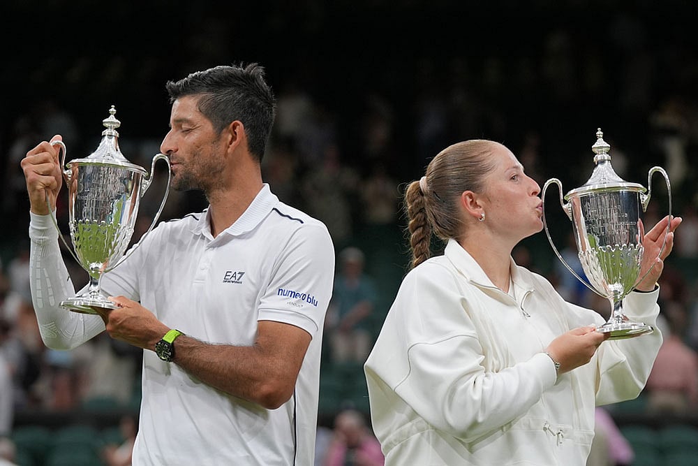Jelena Ostapenko of Latvia and Marcelo Arevalo of El Salvador celebrate kissing the trophy after winning their mixed doubles final match against Marc Polmans of Australia and Storm Hunter of Australia, at the Wimbledon Tennis Championships in London. - | Photo: AP /Maja Smiejkowska