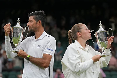 | Photo: AP /Maja Smiejkowska : Jelena Ostapenko of Latvia and Marcelo Arevalo of El Salvador celebrate kissing the trophy after winning their mixed doubles final match against Marc Polmans of Australia and Storm Hunter of Australia, at the Wimbledon Tennis Championships in London.