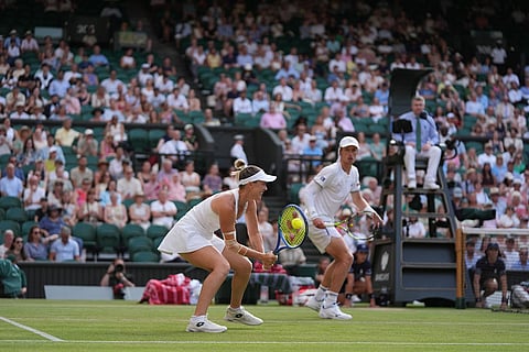 Storm Hunter of Australia hits the ball next to her playing partner Marc Polmans of Australia during their mixed doubles final match against Jelena Ostapenko of Latvia and Marcelo Arevalo of El Salvador, at the Wimbledon Tennis Championships in London.