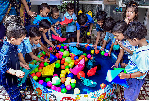 Schoolchildren make paper boats during a monsoon-themed learning activity at a school, in Bikaner, Rajasthan.