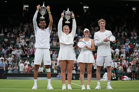 Winners Jelena Ostapenko of Latvia and Marcelo Arevalo of El Salvador, left, celebrate with runners-up Marc Polmans of Australia and Storm Hunter of Australia, right, holding trophies after their mixed doubles final match against Marc Polmans of Australia and Storm Hunter of Australia, at the Wimbledon Tennis Championships in London.