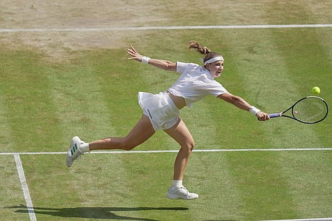 Karolina Muchova of Czech Republic stretches as she hits a return to Coco Gauff of the United States during their women's singles semifinal match at the Wimbledon Tennis Championships in London.