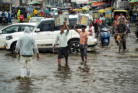 Commuters move on a waterlogged road amid rainfall, in Patna, Bihar.