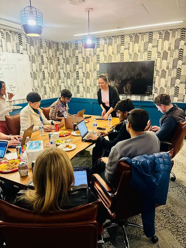 Georgi Boby and colleagues working on laptops around a wooden conference table in a modern office