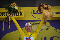 Tim Merlier Wins Seventh Stage, Tadej Pogacar Wins Yellow Jersey At Tour de France | Photo: AP/Mosa'ab Elshamy : Slovenia's Tadej Pogacar, wearing the overall leader's yellow jersey celebrates on the podium after the seventh stage of the Tour de France cycling race with start in Hagetmau and finish in Bordeaux, France, Friday, July 10, 2026.