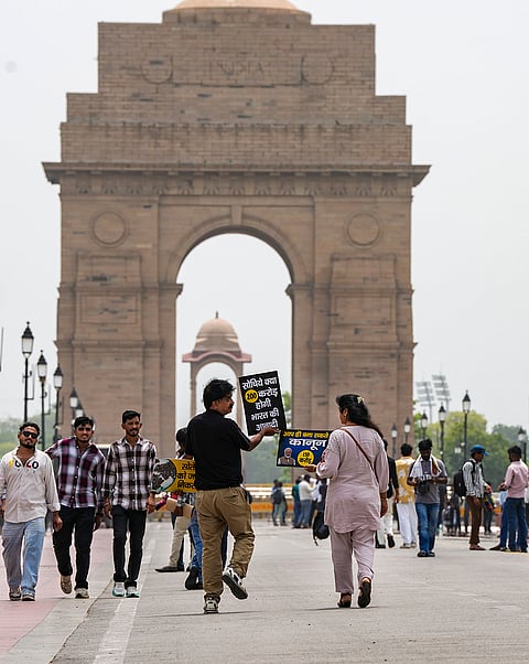 Population control campaigners Dinesh Talwar and Disha Talwar of Meerut walk backwards during an awareness march to mark World Population Day, at the India Gate, in New Delhi.