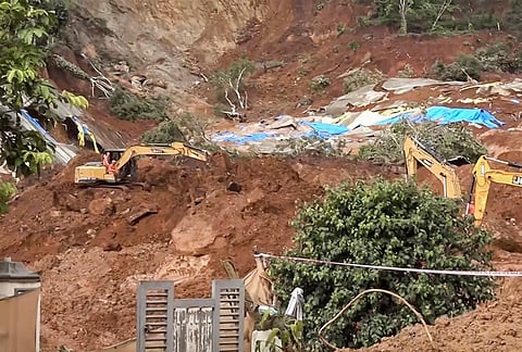 Earthmoving machines remove debris during a clearance operation at the landslide site, in Wayanad district, Kerala.