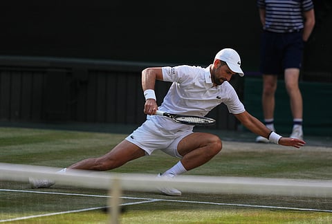 Novak Djokovic of Serbia falls over during his men's singles semifinal match against Jannik Sinner of Italy at the Wimbledon Tennis Championships in London, Friday, July 10, 2026. 