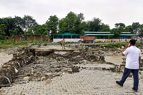 A man stands near a temporary bridge built in Premnagar Nanda ki Chowki after a portion of  the bridge was washed away due to strong river currents, in Dehradun, Uttarakhand.
