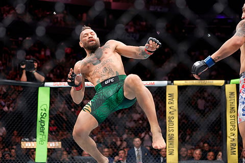 Conor McGregor lands awkwardly after trying to kick Max Holloway at the start of their welterweight fight during UFC 329 in Las Vegas.
