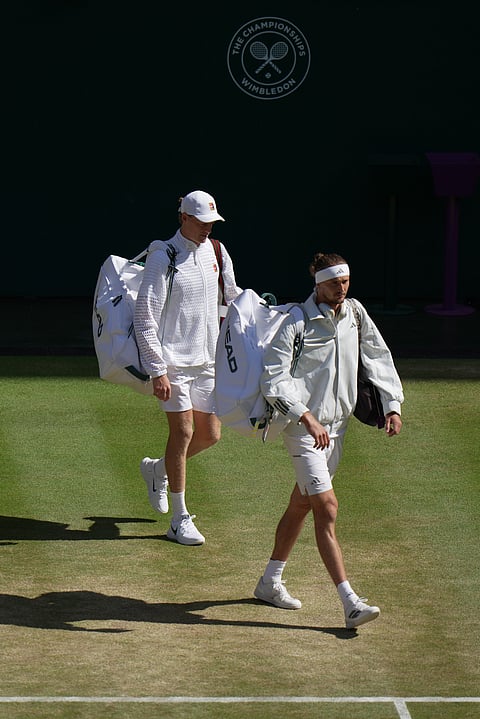 Jannik Sinner of Italy and Alexander Zverev of Germany, right, arrive on court to play the men's singles final at Wimbledon Tennis Championships in London