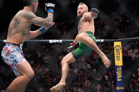 Conor McGregor, right, jumps into the air for a kick as he fights Max Holloway in a welterweight fight at the UFC 329 mixed martial arts event in Las Vegas.