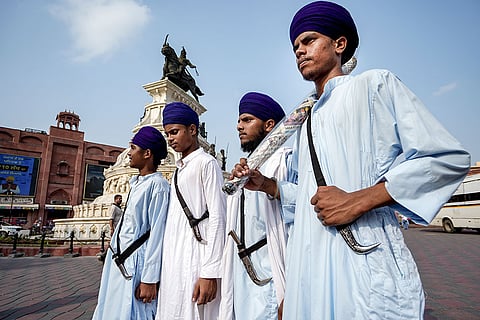Sikhs carrying ceremonial kirpans walk near the Golden Temple, in Amritsar, Punjab.
