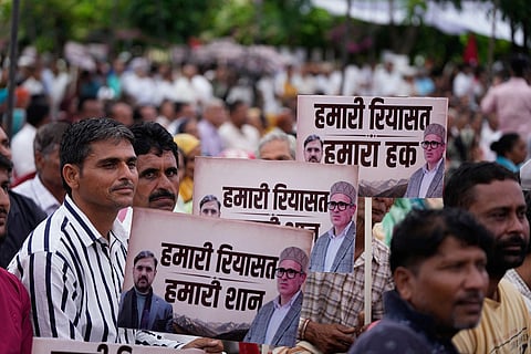 National Conference workers listen to Chief Minister Omar Abdullah's address during a public rally demanding the restoration of statehood to Jammu and Kashmir, in Jammu, India.