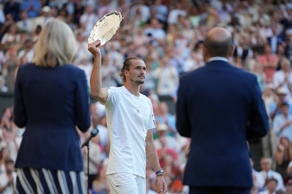 Alexander Zverev of Germany holds up the runner-up plate after playing against Jannik Sinner of Italy in the mens singles final at Wimbledon Tennis Championships in London