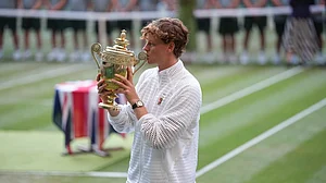 Kirsty Wigglesworth/AP Photo : Jannik Sinner of Italy kisses his trophy after winning against Alexander Zverev of Germany in the men's singles final at Wimbledon Tennis Championships in London