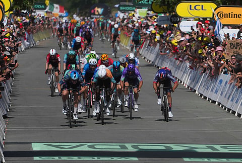 Belgium's Tim Merlier, left, crosses the finish line to win the eighth stage of the Tour de France cycling race with start in Perigueux and finish in Bergerac, France, Saturday, July 11, 2026.