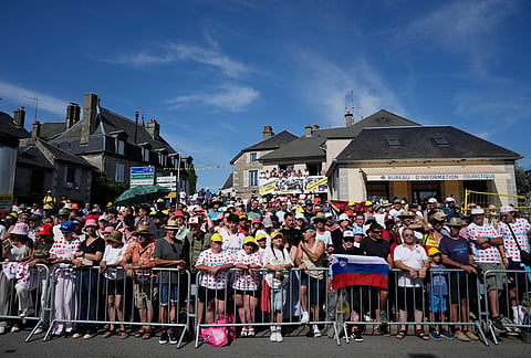 Spectators wait for the riders to pass during the ninth stage of the Tour de France cycling race with start in Malemort and finish in Ussel, France, Sunday, July 12, 2026.