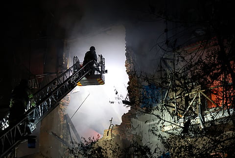 Rescue workers try to put out a fire of a residential building burning after a Russian drone attack on Zaporizhzhia, Ukraine.