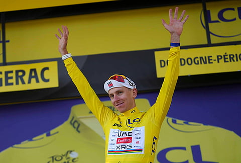 Slovenia's Tadej Pogacar, wearing the overall leader's yellow jersey, celebrates on the podium after the eighth stage of the Tour de France cycling race with start in Perigueux and finish in Bergerac, France, Saturday, July 11, 2026. 