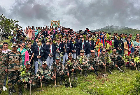 Army personnel along with children and people pose for pictures as they take part in a tree plantation drive carried out by 130 Infantry Battalion ahead of the 'Harela' festival, at Gunsera village and Aganiya village, in Pithoragarh district, Uttarakhand.