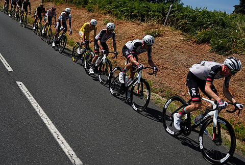 Slovenia's Tadej Pogacar, wearing the overall leader's yellow jersey, rides with the pack during the ninth stage of the Tour de France cycling race with start in Malemort and finish in Ussel, France, Sunday, July 12, 2026. 