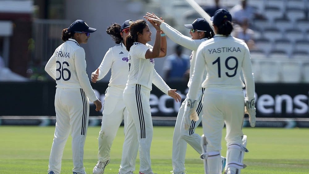 India's Sayali Satghare, center, celebrates with her teammates after taking the wicket of England's Maia Bouchier during day three of the first Women's Test match at Lord's cricket ground in London. - | Photo: Steven Paston/PA via AP