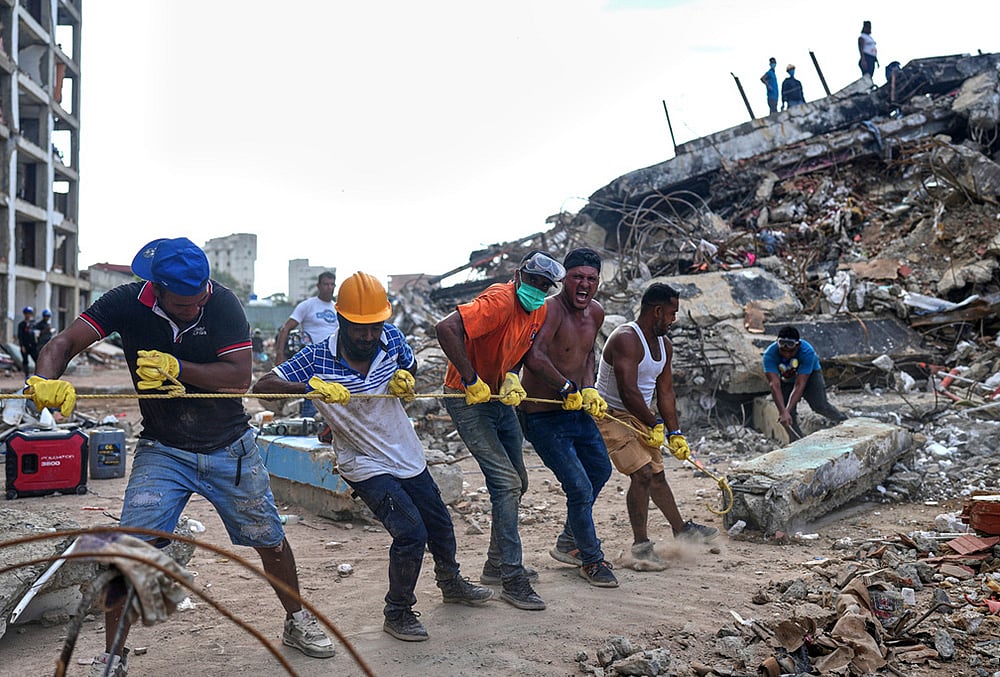 Volunteers pull a rope to remove a debris from a collapsed building by earthquakes in La Guaira, Venezuela. - | Photo: AP/Ariana Cubillos