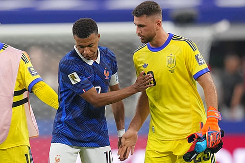 Spain goalkeeper Unai Simon greets France's Kylian Mbappe after Spain defeated France in a World Cup semifinal soccer match in Arlington, Texas, near Dallas, Tuesday