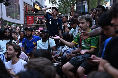 French fans react as they watch a broadcast of the World Cup semifinal soccer match between France and Spain, Tuesday