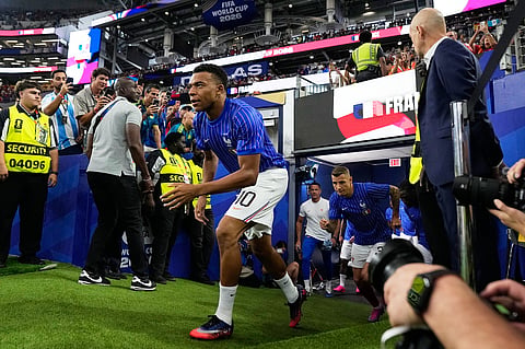France's Kylian Mbappe runs on to the pitch for warmup before the World Cup semifinal soccer match between France and Spain in Arlington