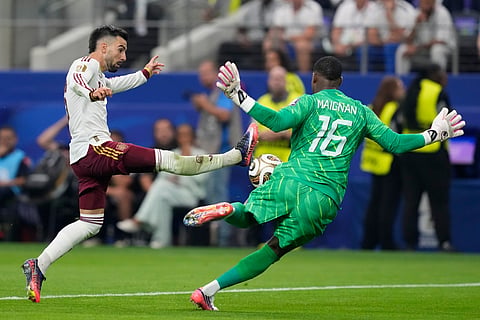 Spain's Alex Baena (15) tries to score against France goalkeeper Mike Maignan (16) during the World Cup semifinal soccer match between France and Spain in Arlington, Texas, near Dallas